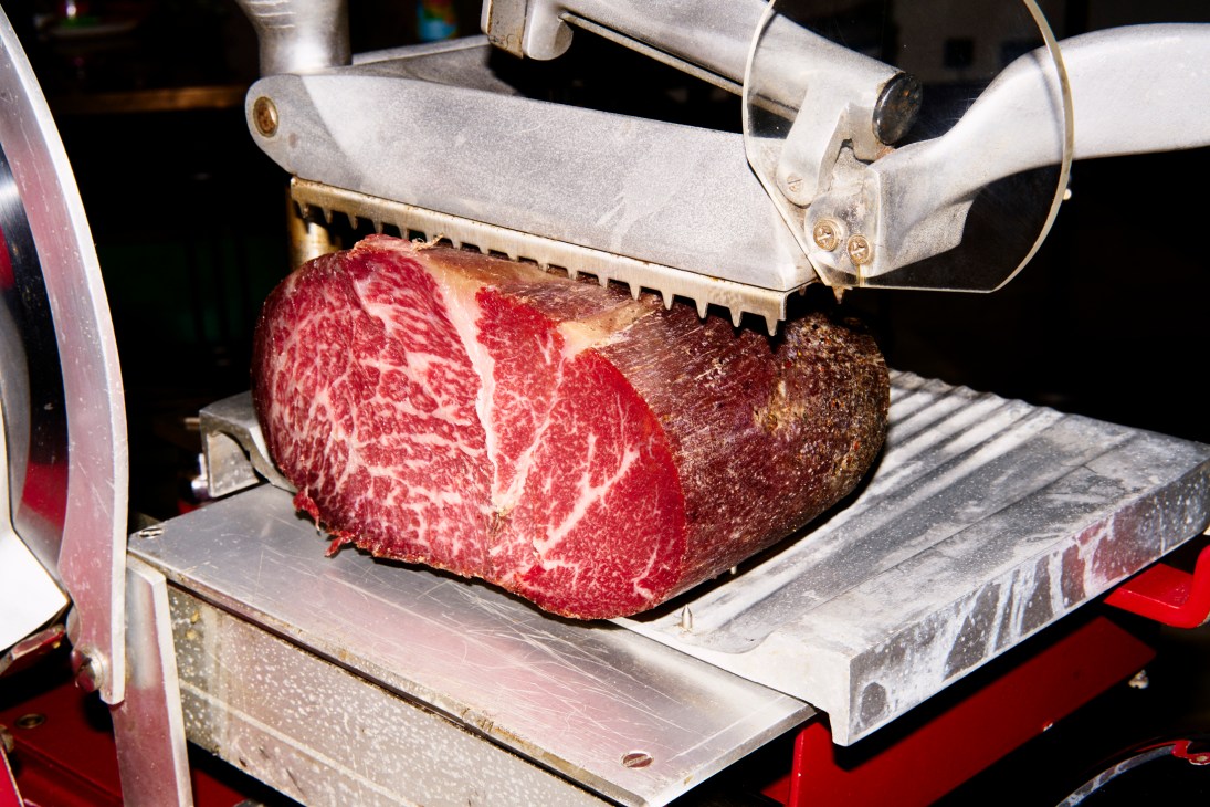 Kobe beef cured Parma-style being sliced on a vintage red Berkel slicer