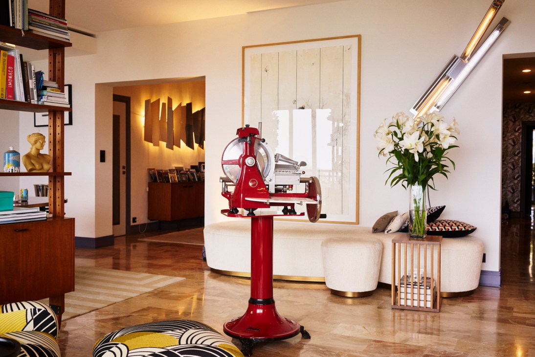 Red vintage Berkel meat slicer in a modern living room with cream furniture and artwork