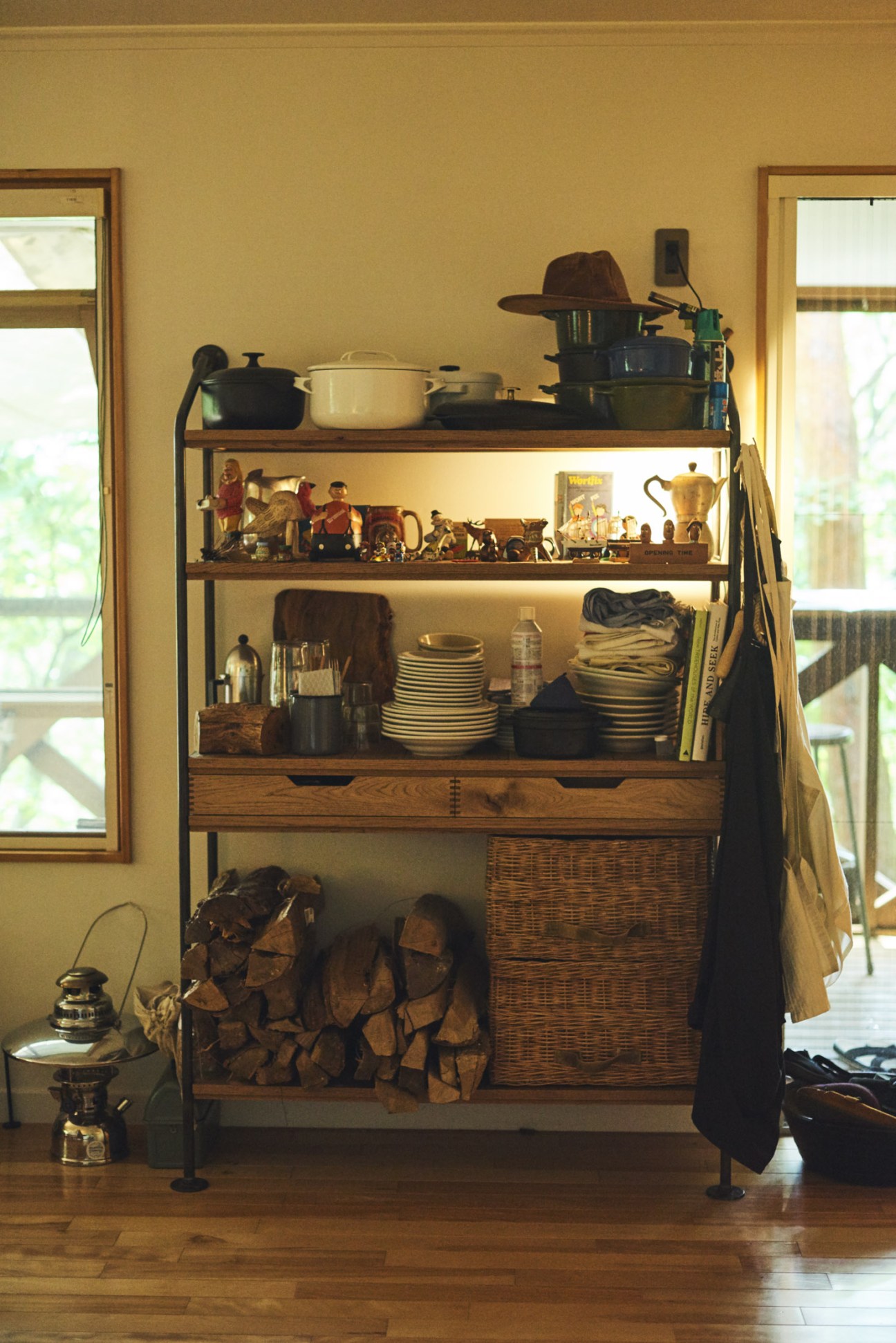 Wooden storage rack by Truck Furniture displaying crockery, cookware, decorative objects and kitchen linens.
