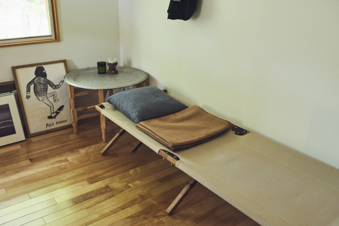 Foldable bed by Mobley Works in a minimalist bedroom with wooden flooring and simple furnishings.