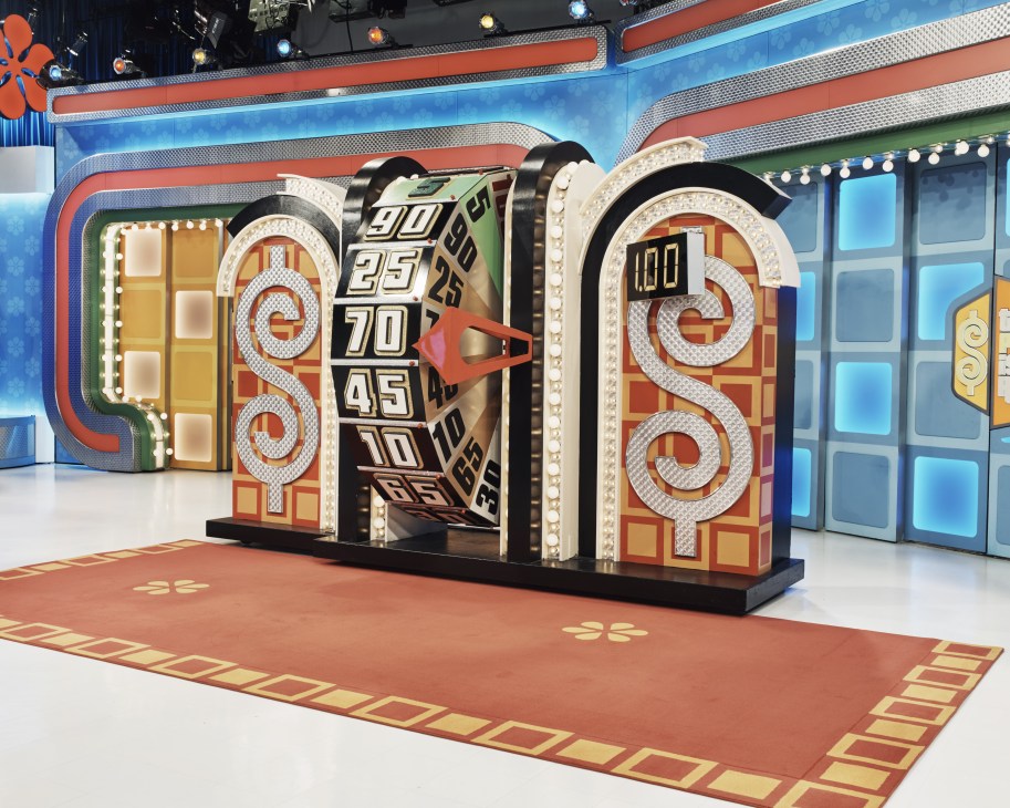 Ornate decorative prize wheel on The Price is Right set with illuminated numbers and red arrow spinner.