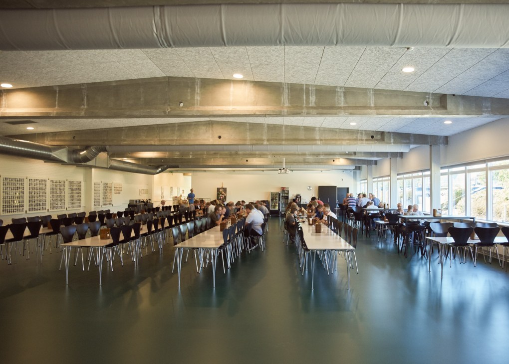Bang & Olufsen employees dining in the Innovation Lab canteen with modern furniture and natural lighting.