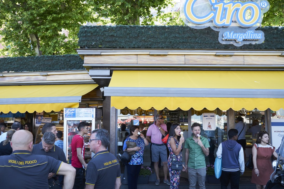 Customers queue outside Chalet Ciro gelato shop with yellow awnings in Naples.