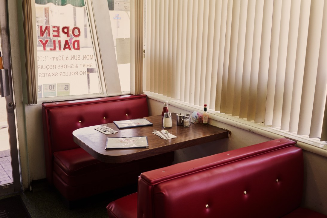 Red vinyl booth seating and wooden table at Rae's Restaurant in Santa Monica