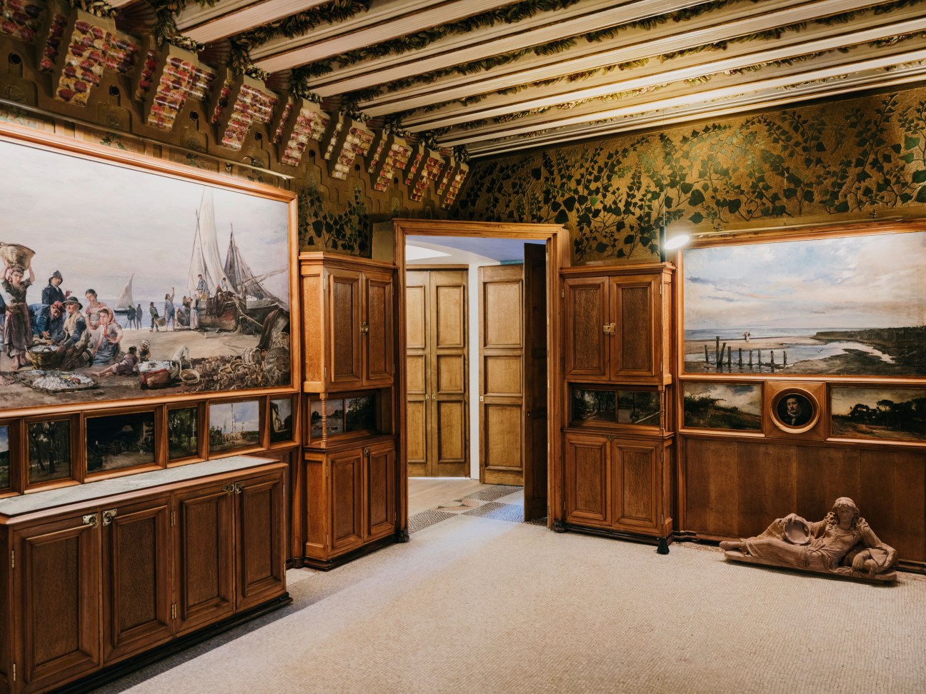 Dining room with Francesc Torrescassana paintings on walls and wooden cabinetry at Casa Vicens.