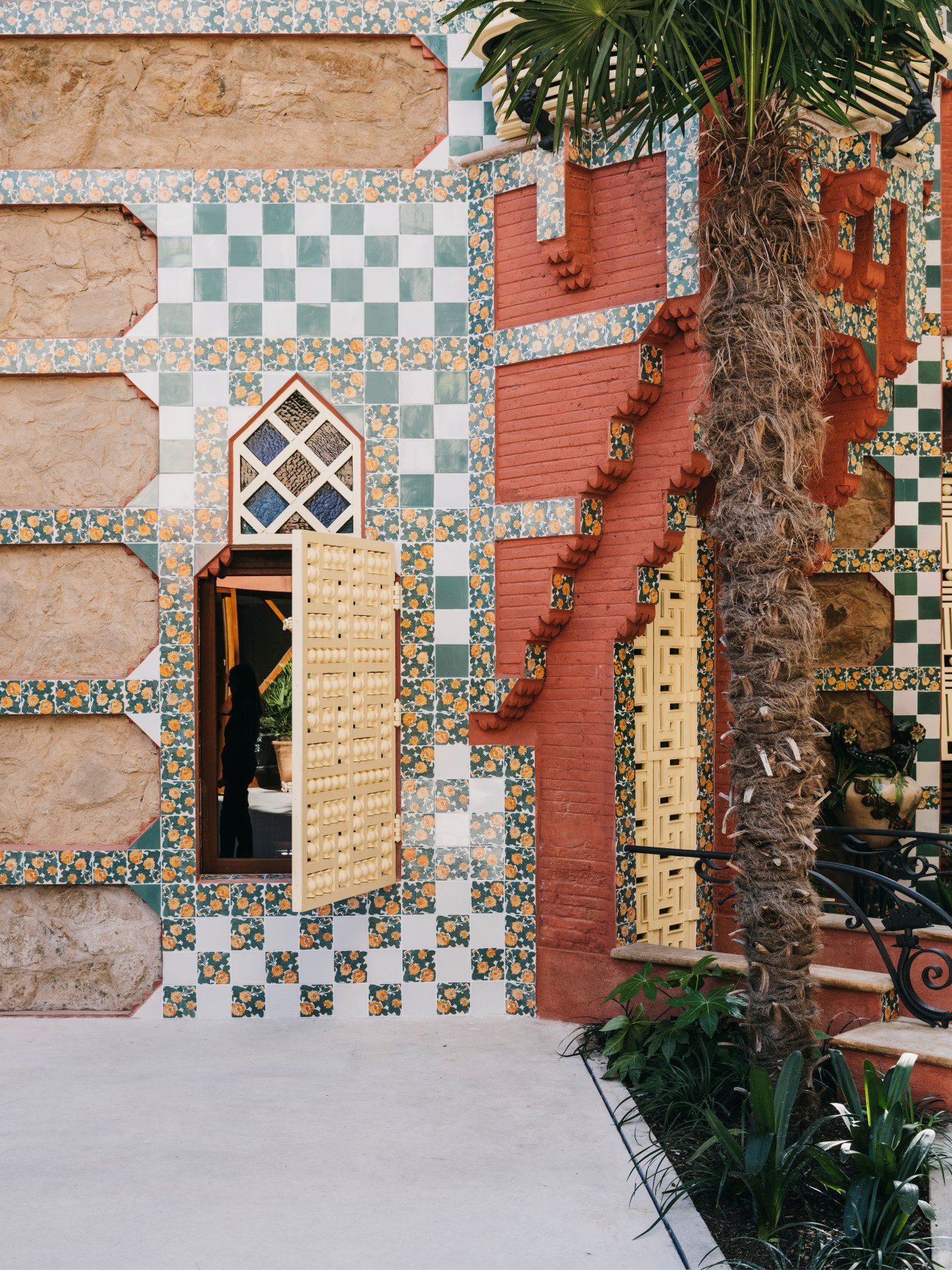 Casa Vicens exterior facade with colorful patterned ceramic tiles, wooden doors, and climbing ivy.