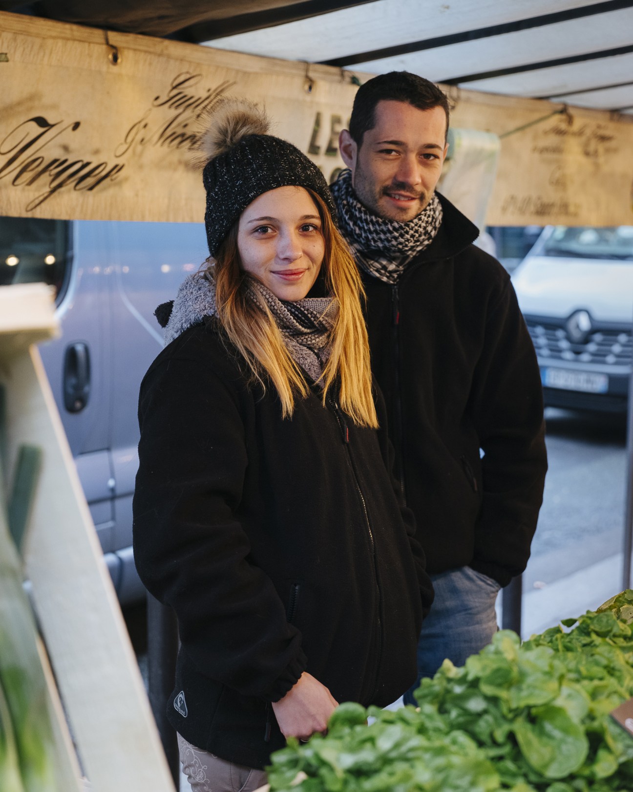 Louise Verger and her partner Jonathan stand together at Boulevard Raspail market in Paris.