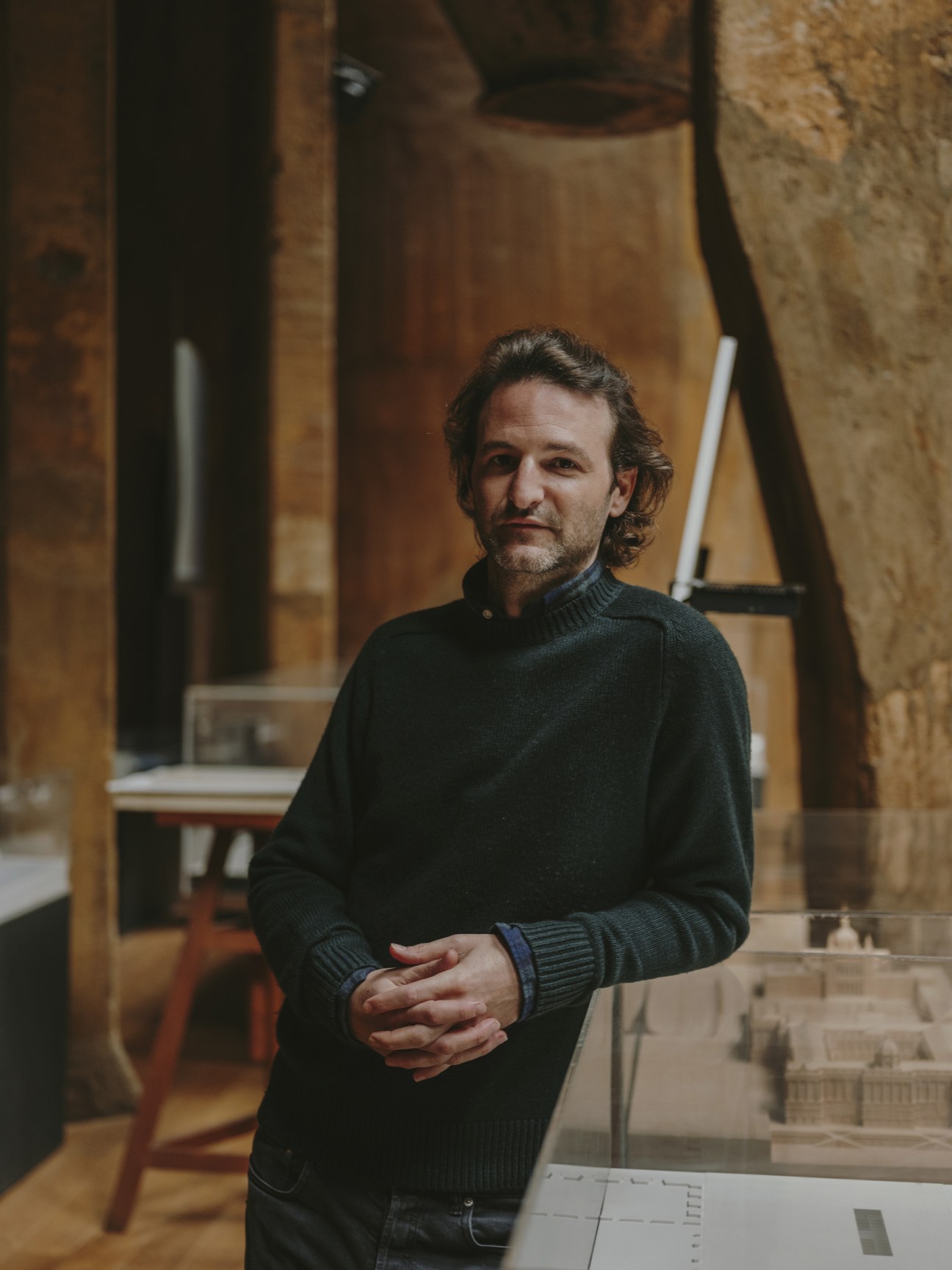 Portrait of Pablo Bofill, CEO of Ricardo Bofill Taller de Arquitectura, standing in the converted cement factory office space.