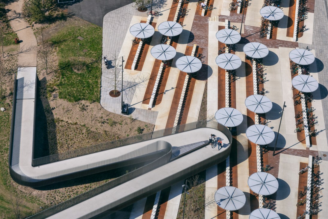 Aerial view of Copenhagen's Maersk Tower elevated walkway with white umbrellas and planted areas.