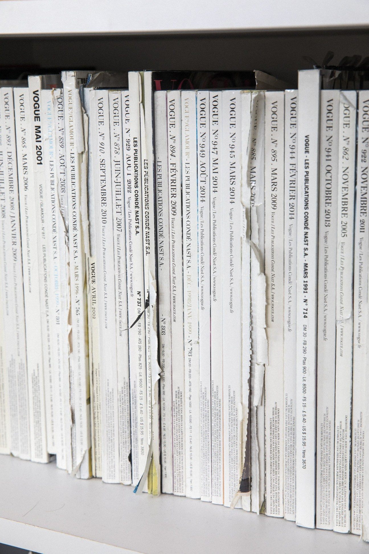 Shelf of bound Vogue Paris magazine volumes with white spines displaying issue dates and numbers