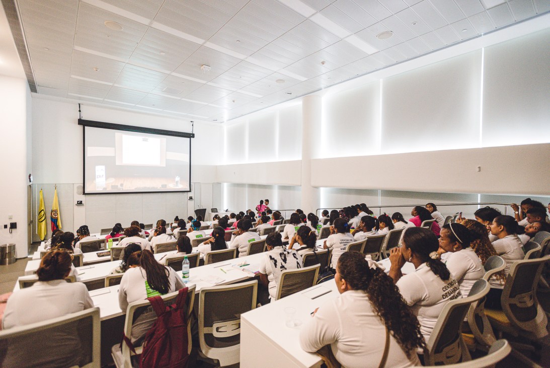 Students in white shirts seated in tiered lecture hall at Los Andes University