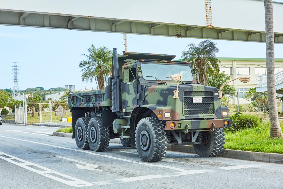 US military truck in camouflage paint driving on a road in Okinawa