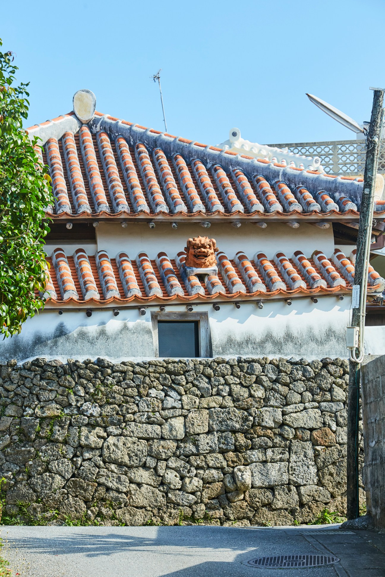 Traditional Okinawan building with distinctive red clay roof tiles and decorative lion guardian sculpture