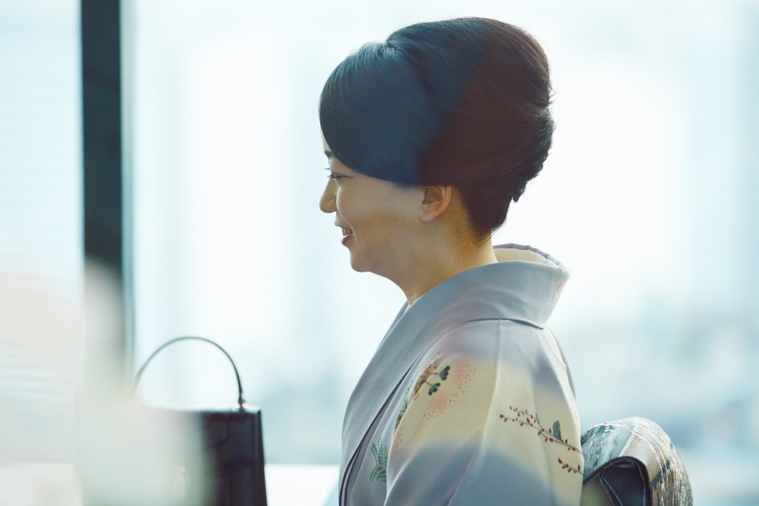 Miwako Date, CEO of Mori Trust, photographed in profile wearing glasses against a bright window.