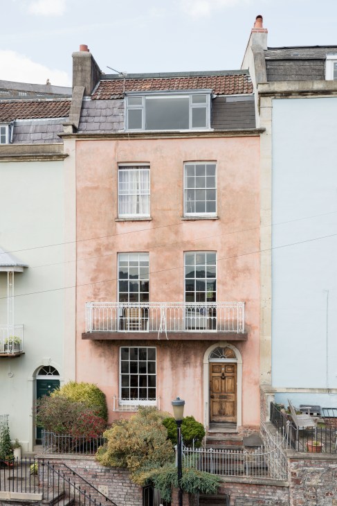 Pink-rendered four-storey townhouse with metal railings in Bristol's Hotwells area.