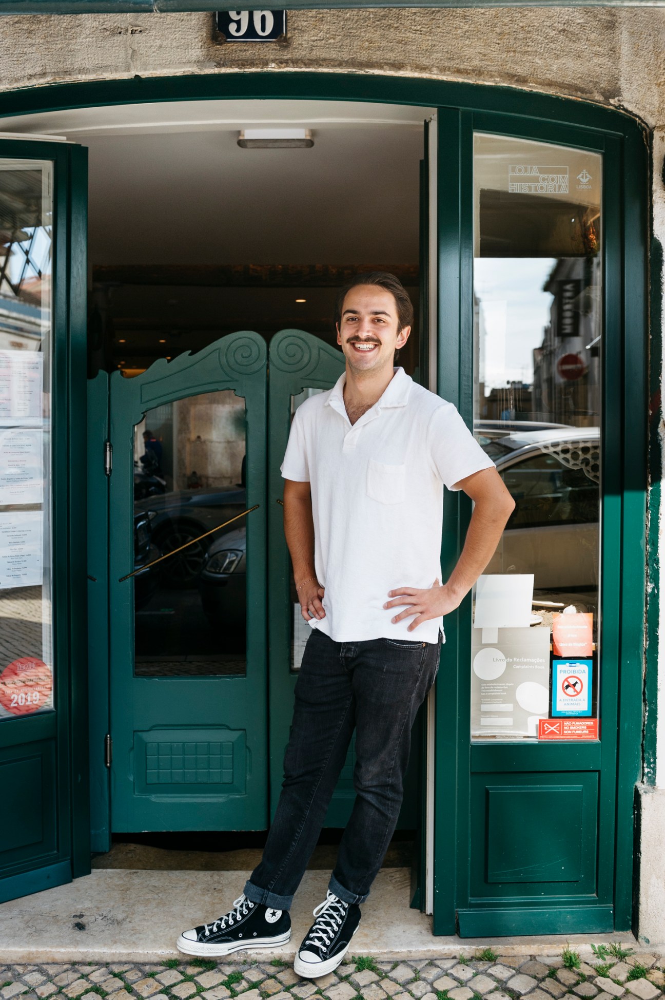 Jorge Marques stands smiling in the doorway of his restored tasca Faz Frio in Lisbon