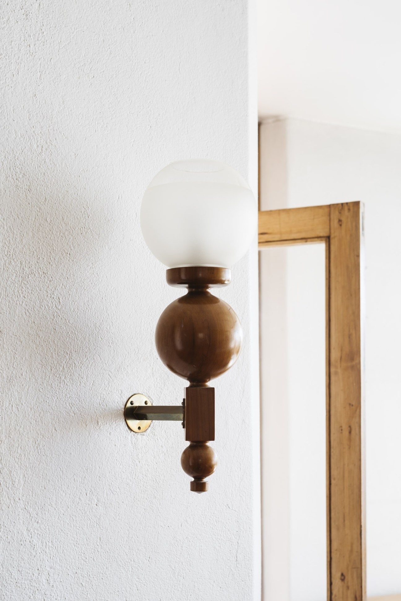 Mid-century modern wall lamp with wooden spheres and white glass globe designed by architect's wife Carmo Valenta.
