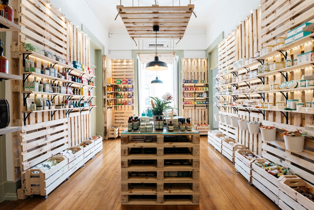 Interior of Granado shop at Casa Pau-Brasil displaying Brazilian cosmetics and products on wooden shelving.