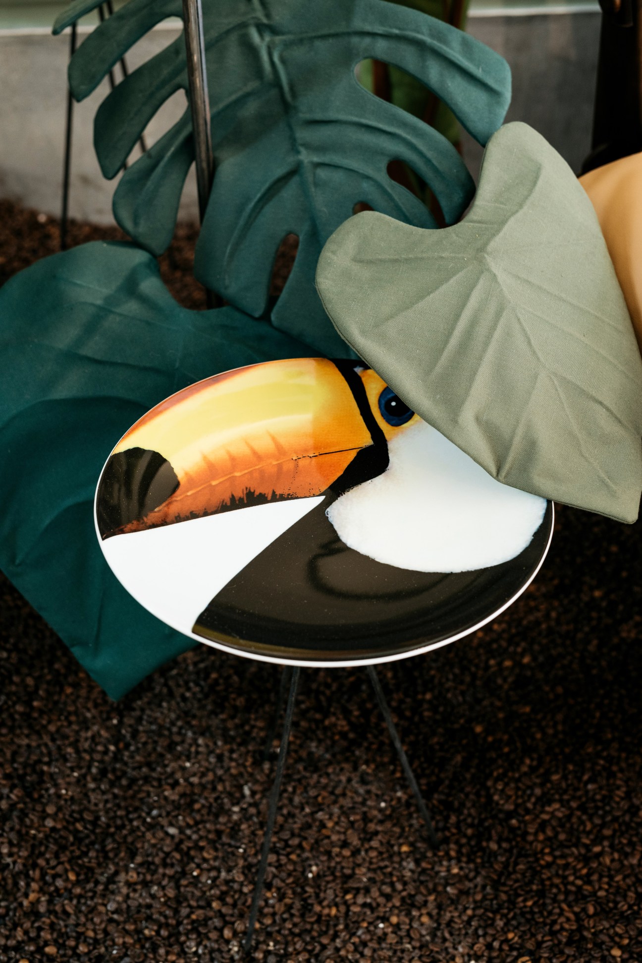 Toucan table with tropical plant leaves and geometric cushions at Casa Pau-Brasil