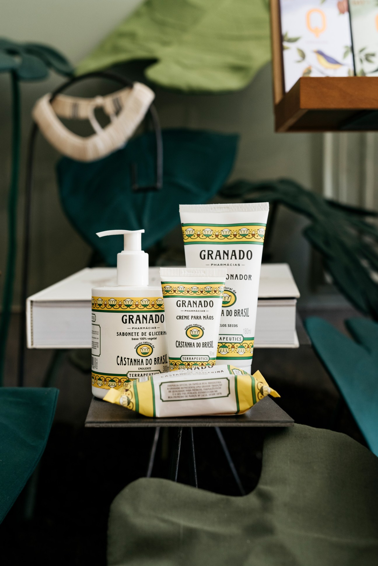 Granado Brazilian soap and cosmetic products displayed on a black table with green chairs in background.