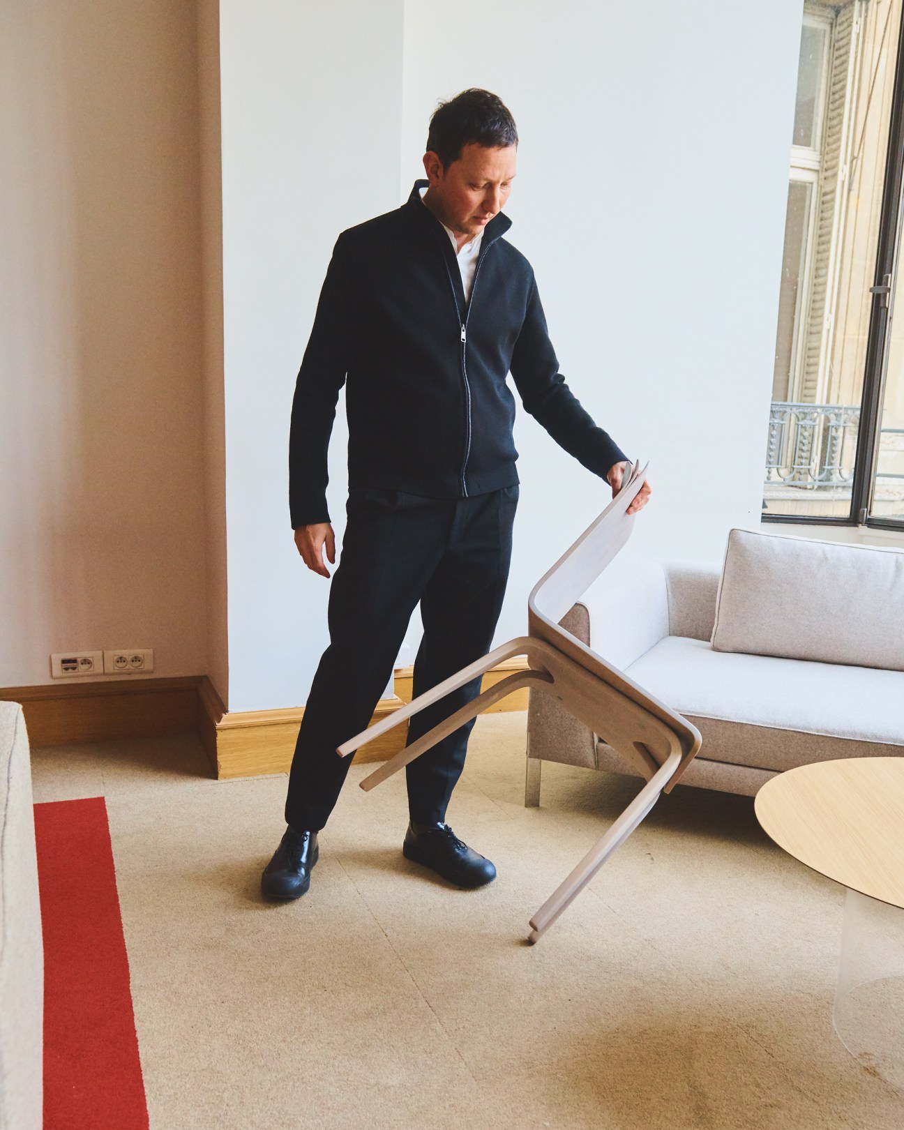 Ramy Fischler, founder of RF Studio, examines design samples in a minimalist interior space.