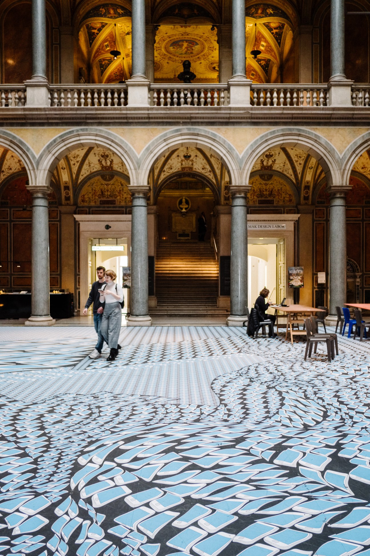 Thomas Bayrle exhibition installation at Museum of Applied Arts showing geometric blue and white floor pattern under ornate Renaissance-style arches.