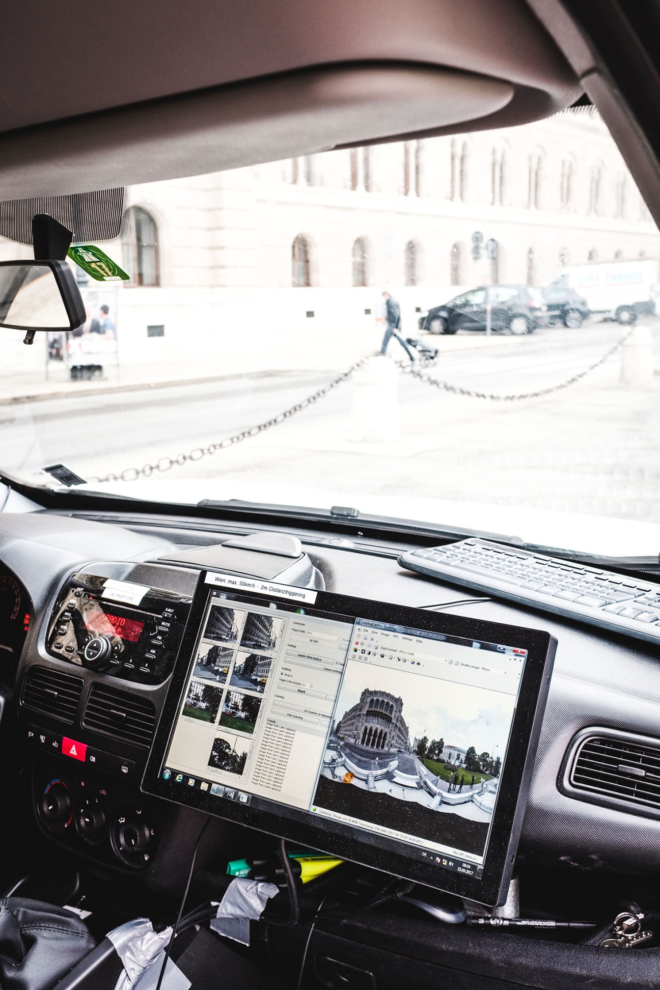 Interior of a mobile-mapping van showing multi-image screens displaying 360-degree street views of Vienna.