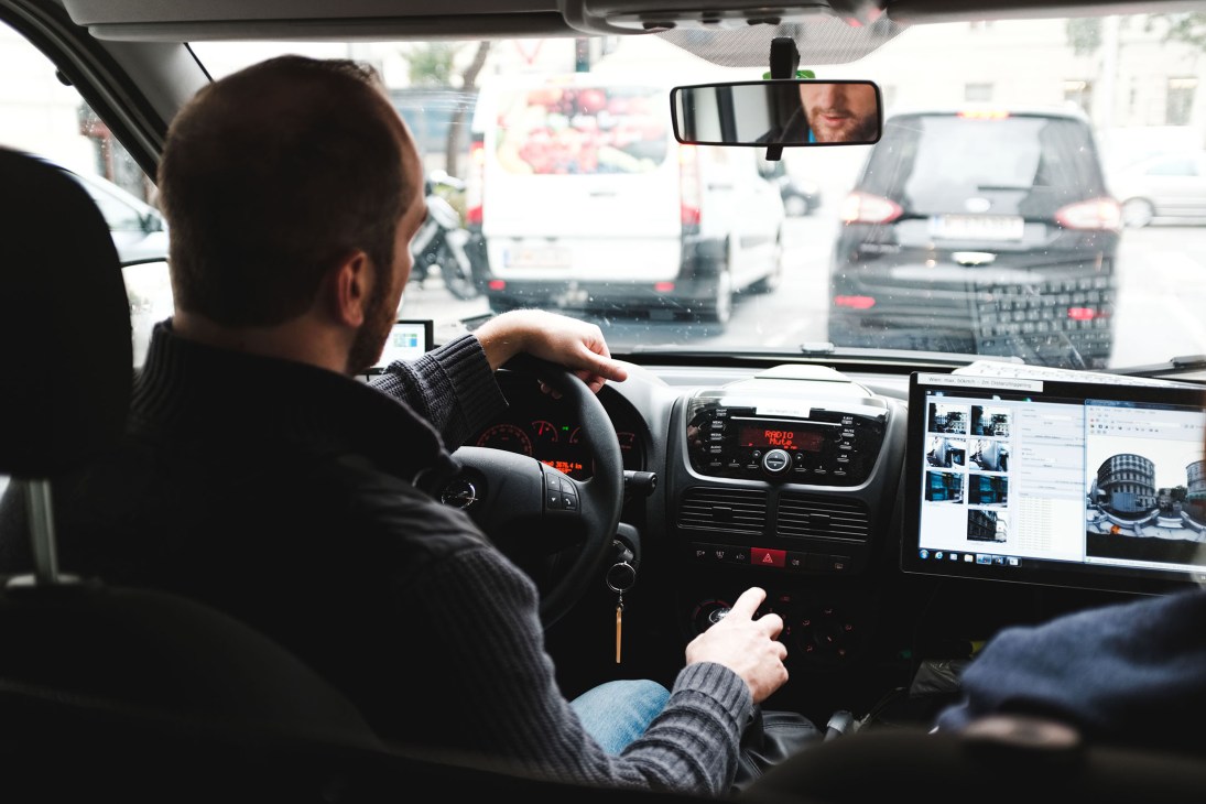 Driver operates mobile-mapping van with multi-image display screens showing real-time street views in Vienna.