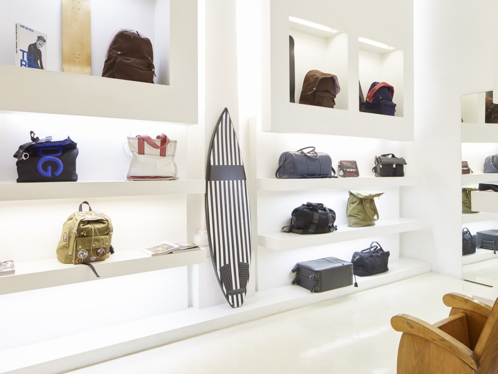 White shelving displays luxury handbags and accessories at Rail boutique in Brescia