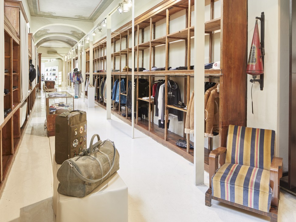 Interior of Rail boutique in Brescia displaying colorful coats and designer garments on wooden shelves