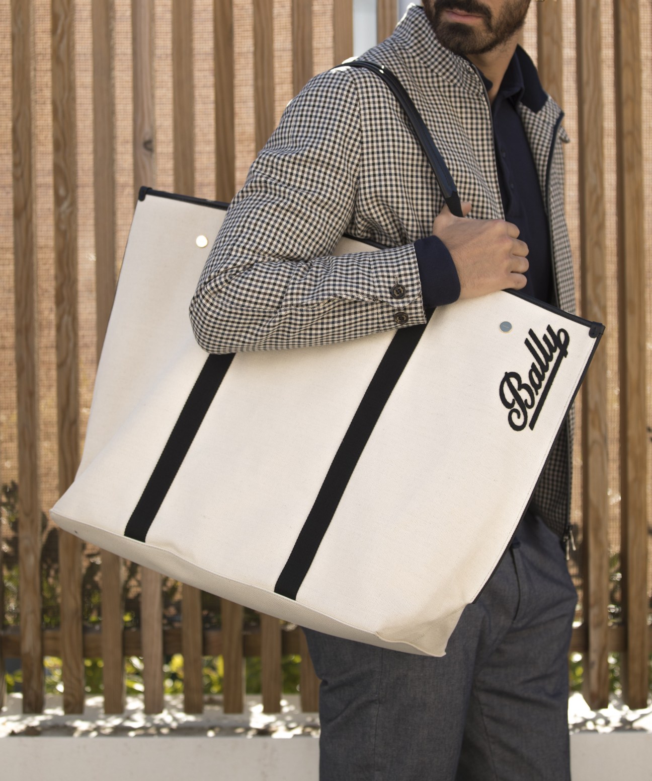 Model in Sealup jacket with Orazio Luciano polo shirt and Briglia 1949 trousers, carrying Bally bag
