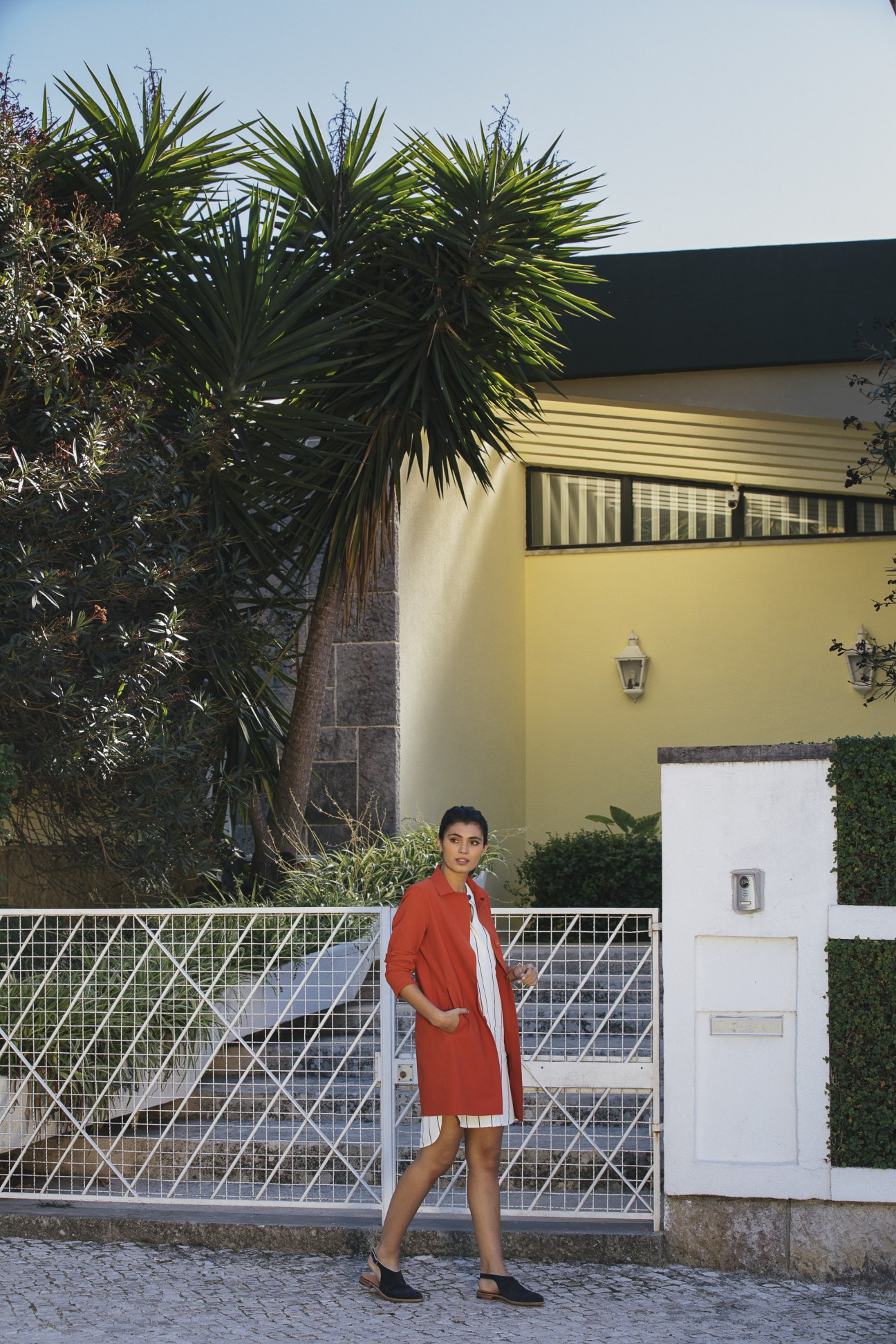 Model wearing Herno coat with Jacob Cohën dress and John Lobb shoes in Lisbon's Restelo district.