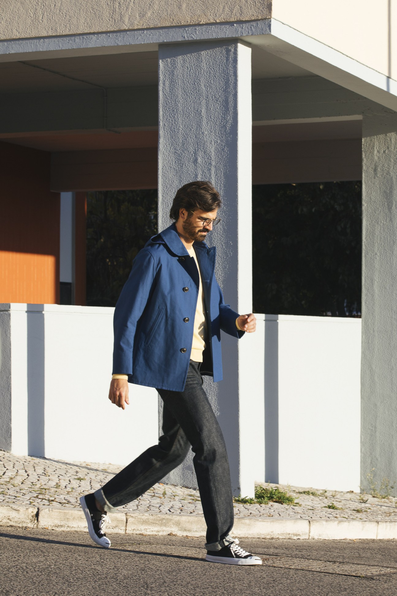 Man wearing Orcival jacket over Altea jumper with Louis Vuitton jeans and Converse trainers in Lisbon's Restelo district