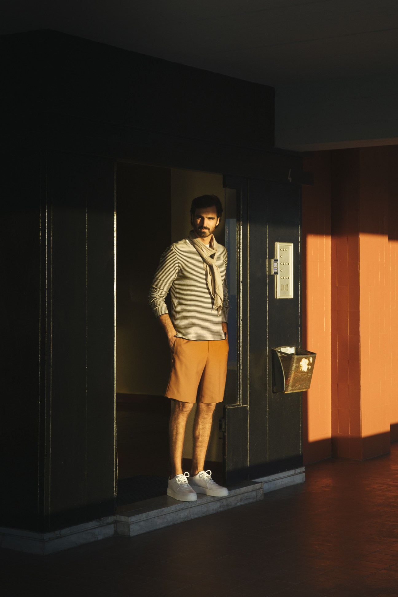 Model wearing Oliver Spencer striped jumper, Tomorrowland shorts, and Bally trainers in Lisbon's Restelo district