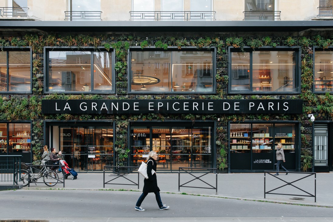 La Grande Épicerie de Paris storefront with green ivy-covered facade and large display windows.