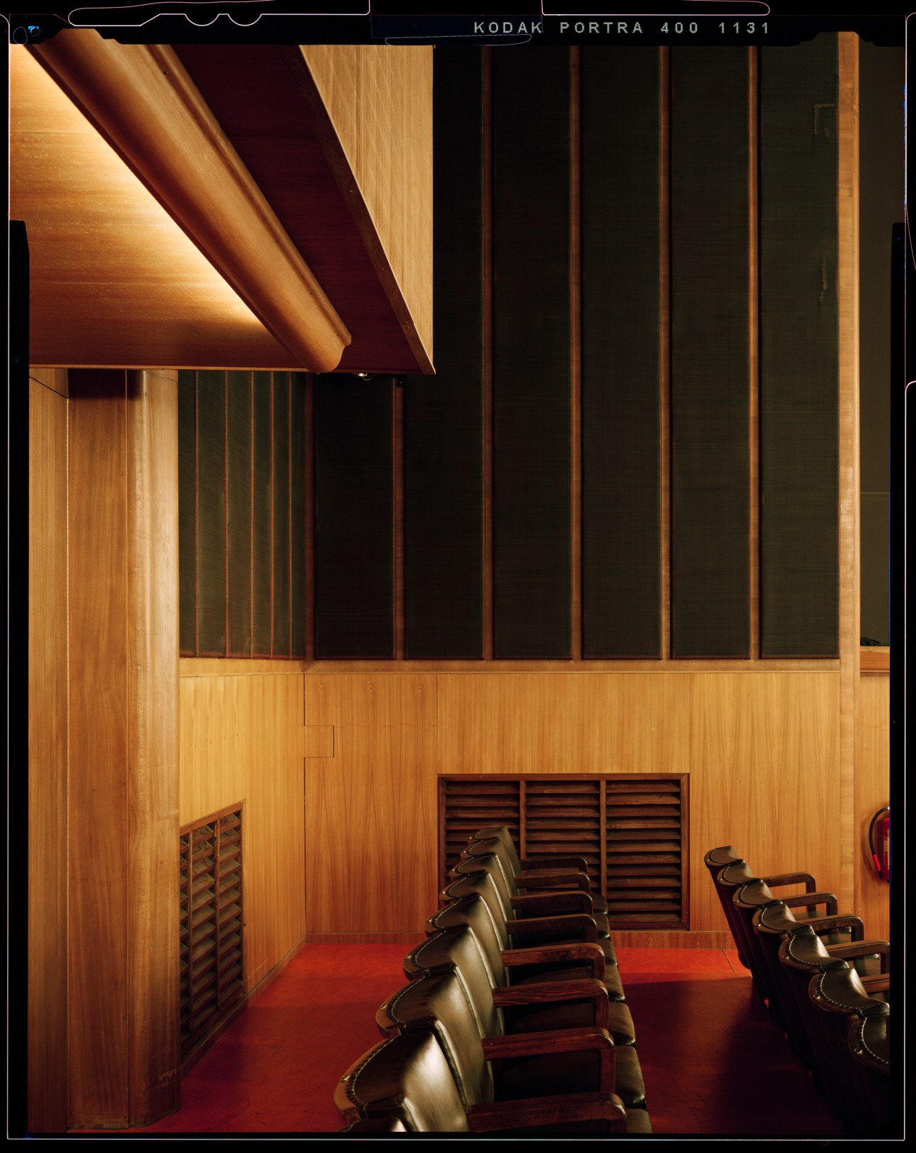 Rows of leather chairs in a recording hall with wood-paneled walls and acoustic slat panels