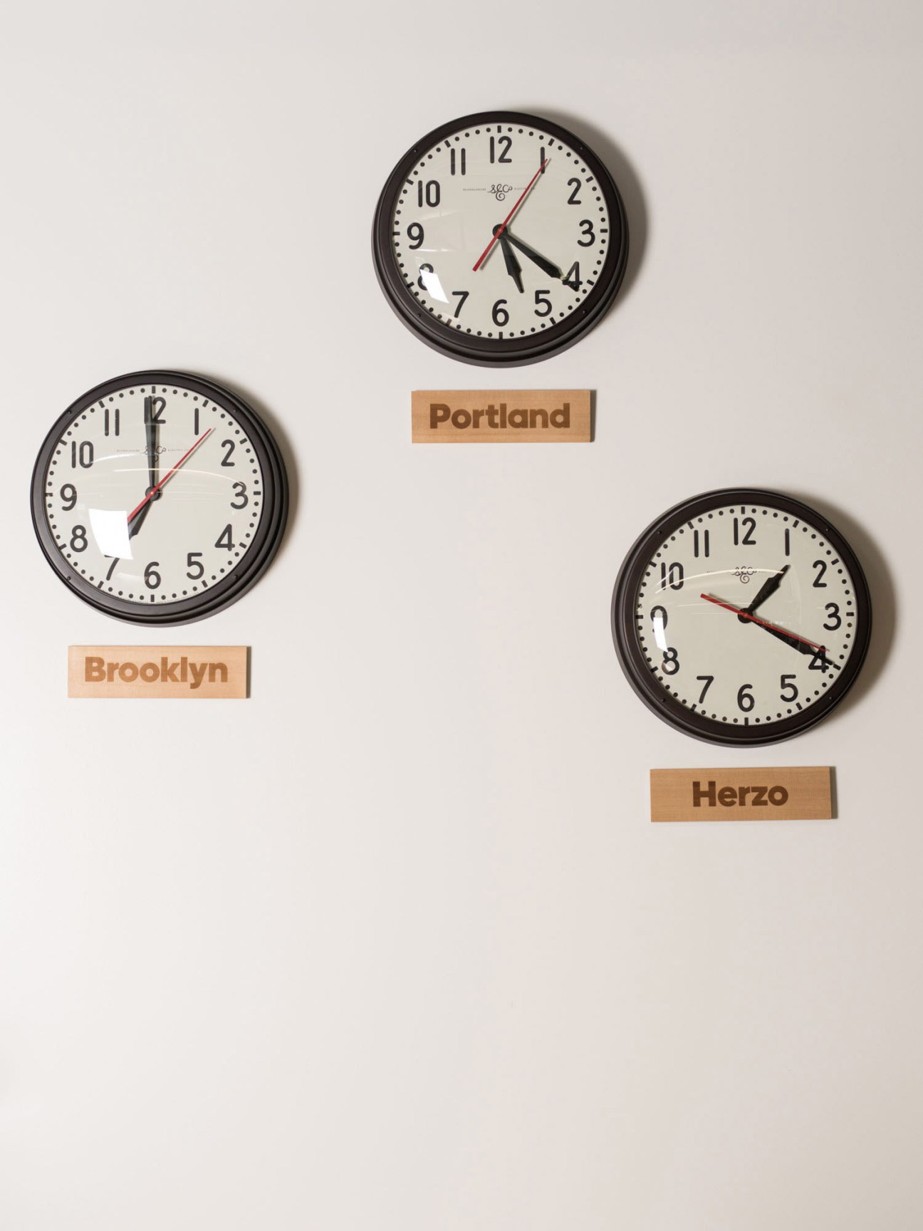 Three clocks showing different times labeled Brooklyn, Portland, and Herzo, representing Adidas's major office locations.