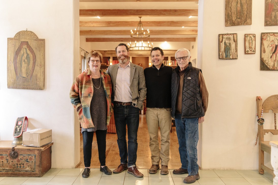The Rembe family standing together in their home: Penny, Matt, Jay and Armin.