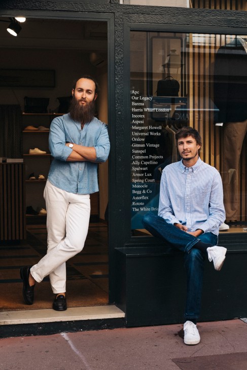 Two men posing outside St Germain menswear shop with brand names displayed on window