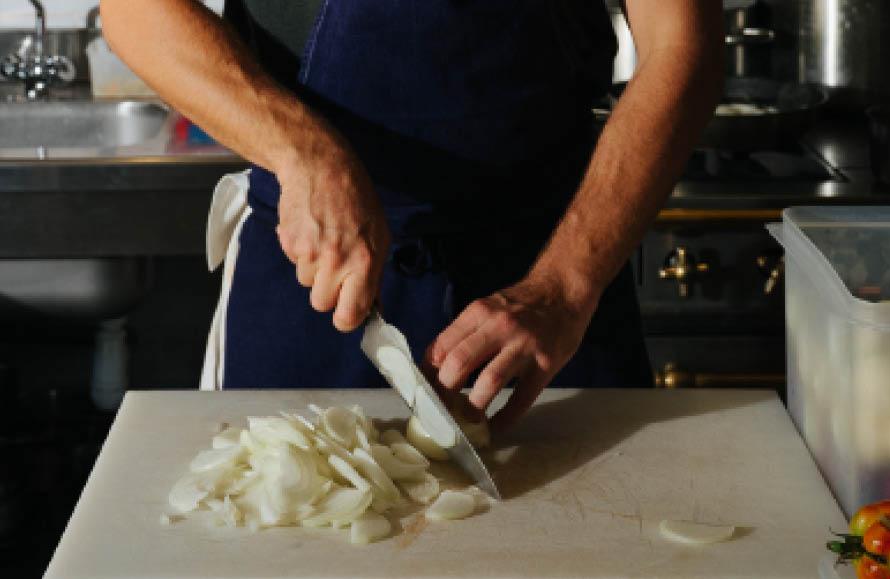 Food being sliced in the kitchen at the Arles supper club