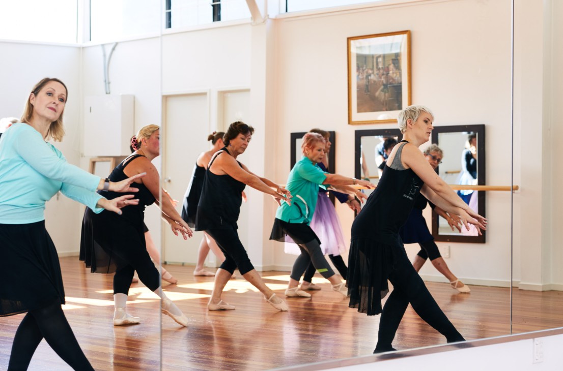 Senior women performing ballet movements in a mirrored studio during a Senior Swans class at Auckland Academy of Adult Ballet.
