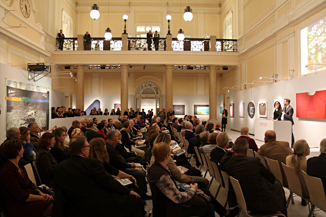 Packed auction room at Dorotheum with bidders seated facing auctioneers in ornate neo-baroque interior