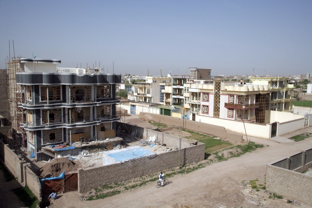 New mansions under construction in Herat, Afghanistan with ornate facades and mirrored glass details.