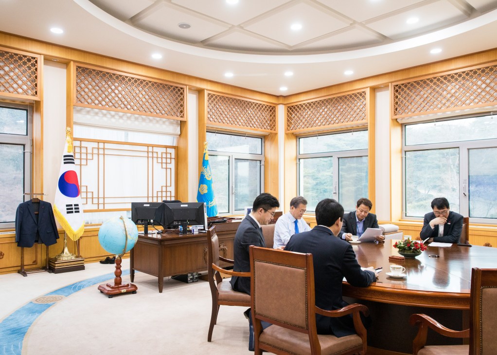 President Moon Jae-in meets with advisers around a wooden conference table in his Blue House office.