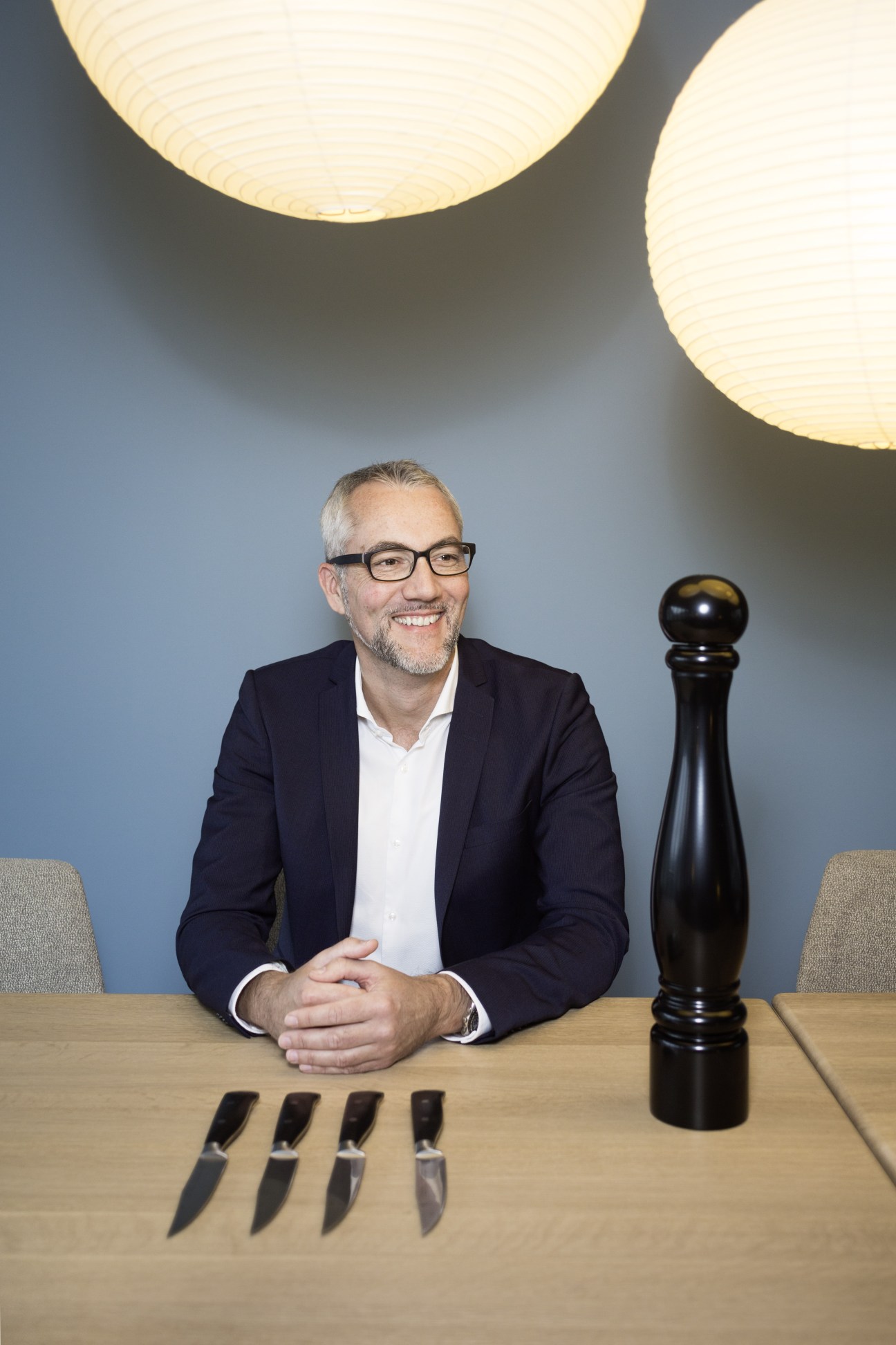 Axel Korda, director of the brand business department at G+J, seated at a table with knives and a pepper mill.
