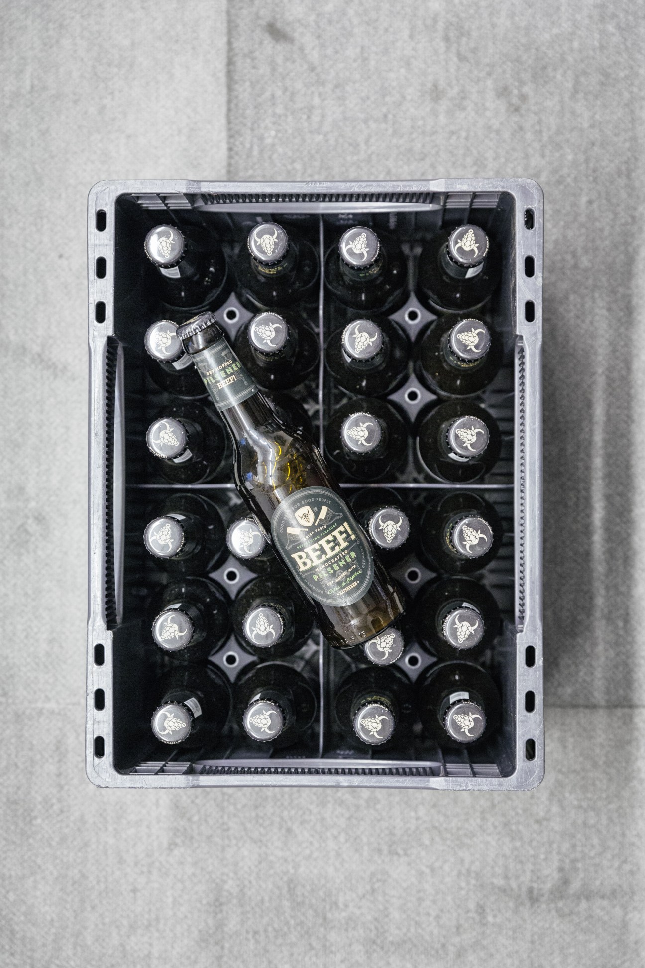 Beef! branded beer bottle displayed in a crate with other bottles featuring the Beef! logo