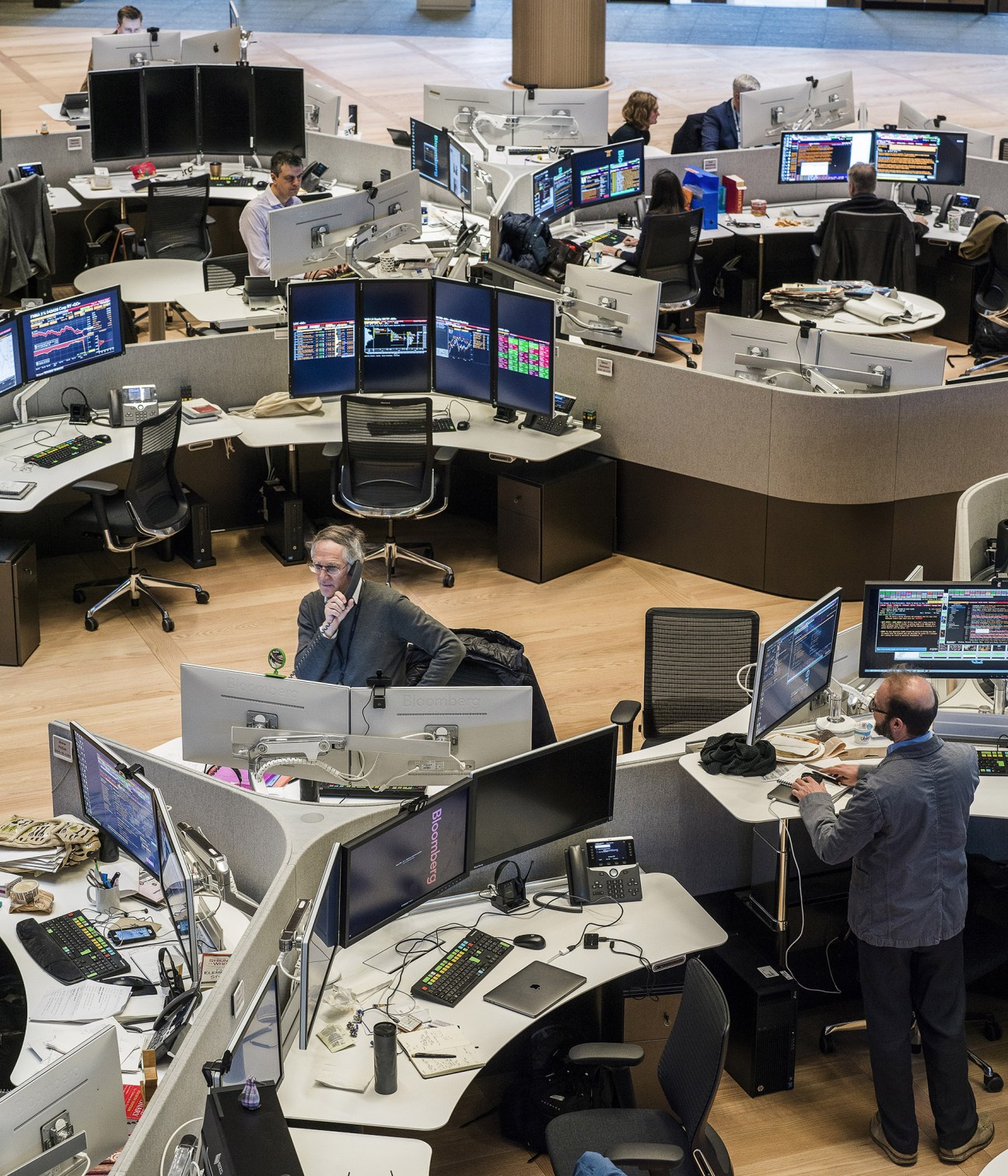 Bloomberg office workspace with curved collaborative desks at 120-degree angles and multiple monitors