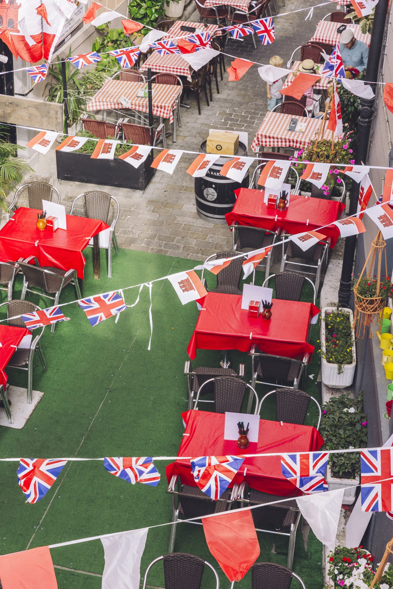Outdoor restaurant seating decorated with British and Gibraltarian flags strung overhead.