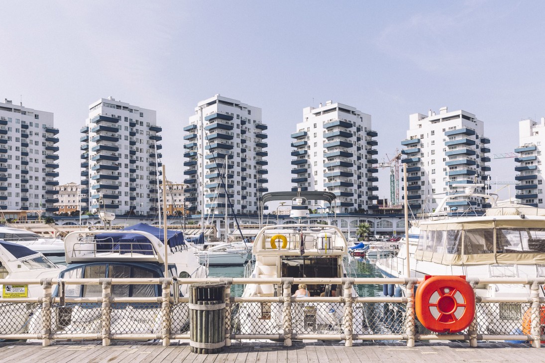 Marina Bay in Gibraltar with moored boats and modern residential apartment buildings in the background.