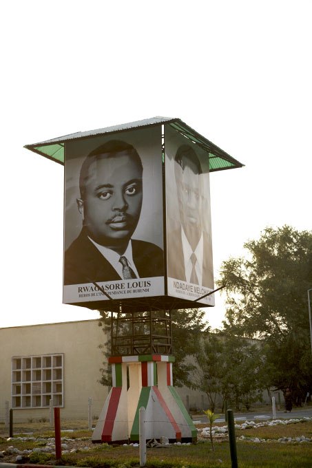 Large outdoor poster displaying portraits of Prince Louis Rwagasore and President Melchior Ndadaye, assassinated Burundi leaders